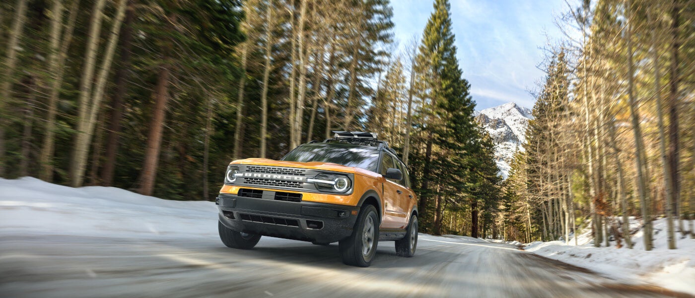 2026Ford-Bronco-ExteriorDrivingHeadOnInSnowyMountainForest